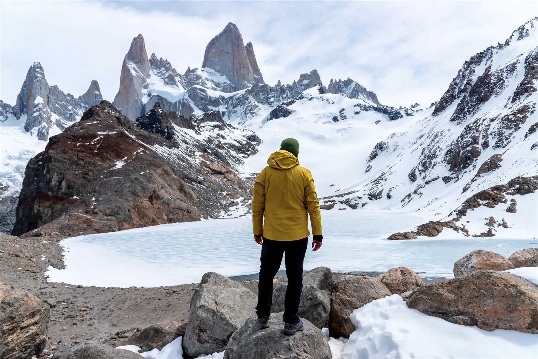 Caminhante de casaco amarelo aos pés do Fitz Roy, em El Chaltén