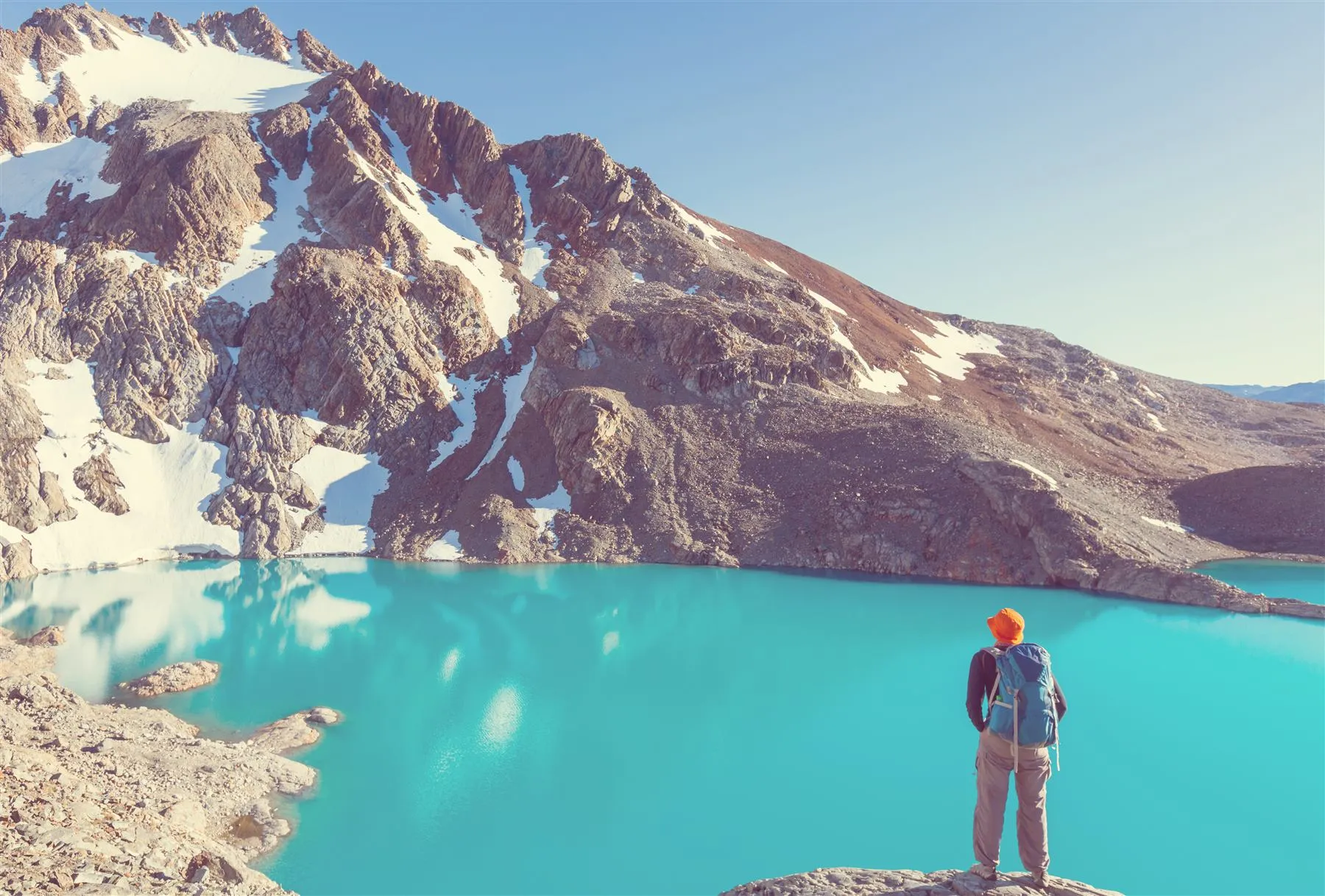 Caminhante diante de uma lagoa glaciar turquesa